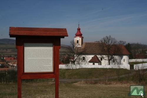 Ismertető Pokoljáró Tar Lőrinc váráról, háttérben Szent Mihály főangyal temploma 